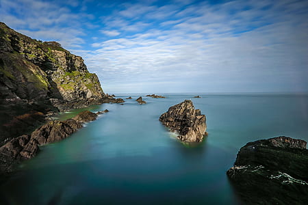 photo of grey rock formations on water during daytime thumbnail