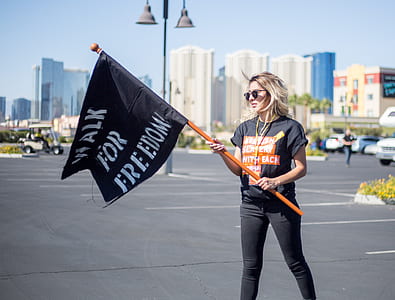 woman holding Walk for Freedom flag near lamp post thumbnail