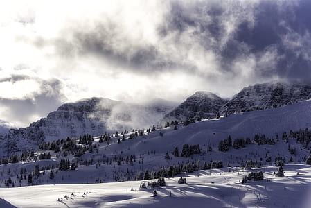 snow covered mountain under white clouds during daytime thumbnail