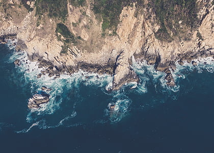 bird's eye view photography of mountain beside body of water thumbnail