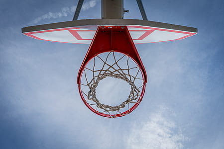 low-angle photography of red basketball hoop under cloudy sky thumbnail