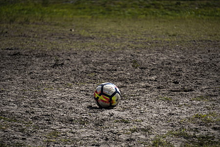 white, black, and red soccer ball on soil thumbnail