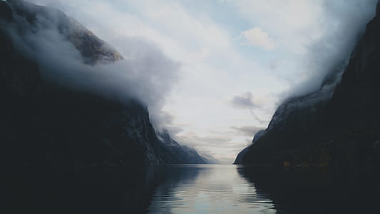body of water between two mountains during daytime thumbnail
