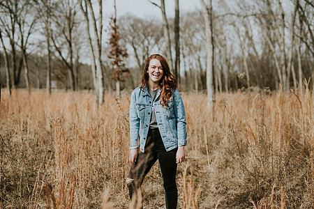 woman standing on grass field surrounded trees thumbnail