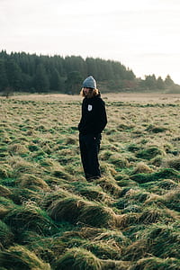 man standing on grass field near green leaf trees thumbnail