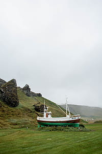 white and green fishing vessel on lawn during daytime thumbnail