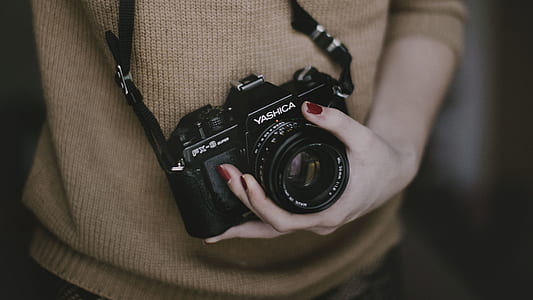 person's holding black Yashica DSLR camera thumbnail