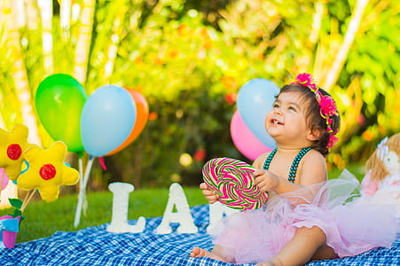 baby sitting on mat beside balloons thumbnail