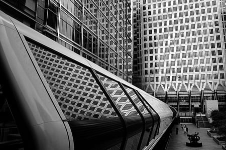 people walking on hallway near buildings greyscale photography thumbnail
