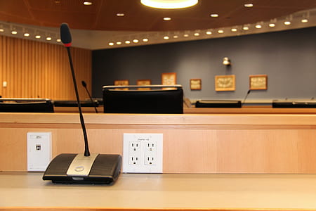 black conference microphone on beige wooden table thumbnail