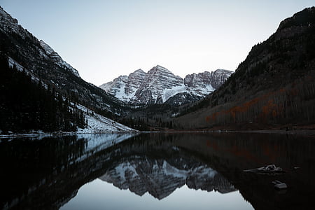 photo of body of water between mountains during daytime thumbnail