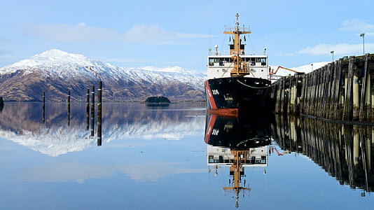 white, black, and red boat on body of water near dock at daytime thumbnail