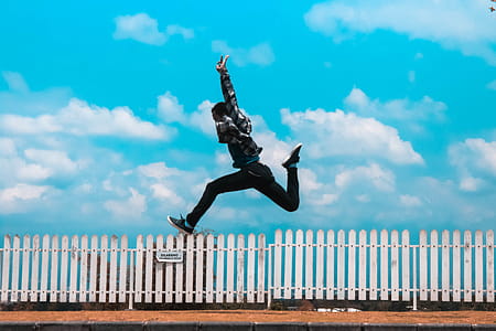 Man Jumping over White Fence thumbnail