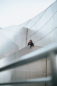 woman standing on gray architectural building thumbnail