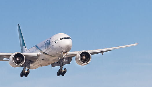 white passenger plane flying through sky thumbnail