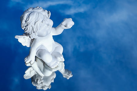 white ceramic cherub figurine reflects on blue water thumbnail