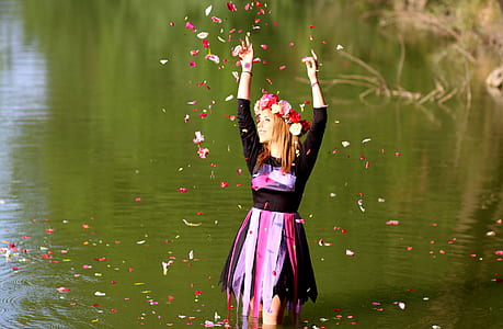 woman throwing petaled flowers in river thumbnail