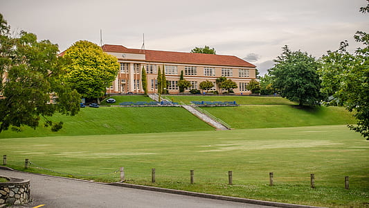 beige and red building across green plains thumbnail
