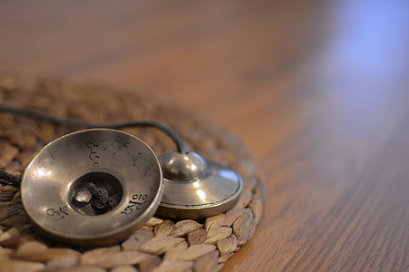 two round gray metal tools on brown wicker mat on table thumbnail