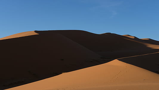 brown sand with shadow under blue sky at daytime thumbnail