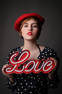 woman holding white and red love neon sign thumbnail