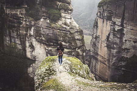woman standing in front of rock formations during daytime thumbnail