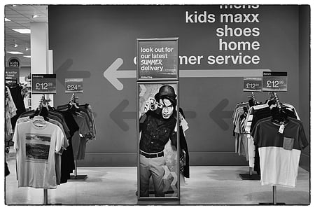 greyscale photo of hanging clothes and signage thumbnail
