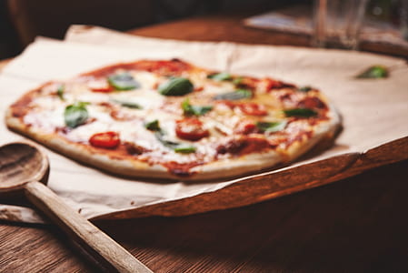 pizza beside brown wooden spoon thumbnail