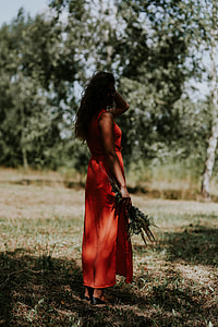 Woman in a red dress with flowers outdoors thumbnail