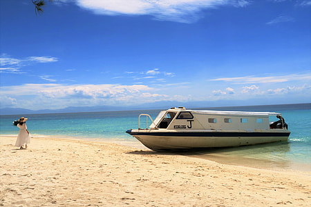 woman wearing whited dress standing near white boat at daytime thumbnail