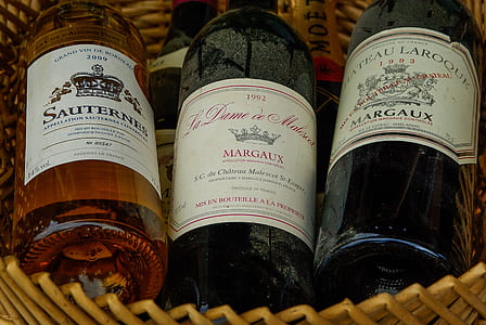 three assorted labeled bottles on brown basket thumbnail