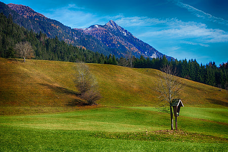 grass field beside mountain during daytime thumbnail