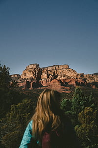 woman looking right facing the forest and stone mountain during day thumbnail