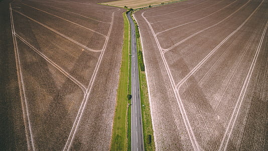 aerial photography of blacktop road between fields thumbnail