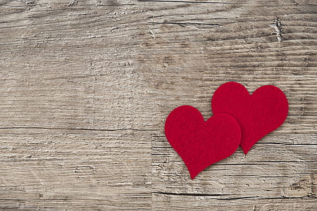 two cutout hearts on brown wooden surface thumbnail