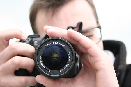 person holding DSLR camera while taking picture thumbnail