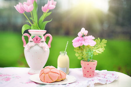pink petaled flower centerpiece on table beside bread thumbnail
