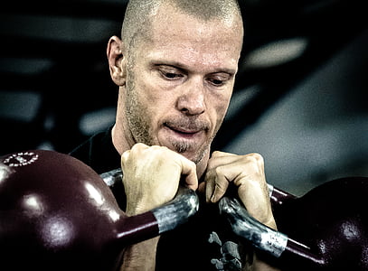 man lifting black kettle bells thumbnail