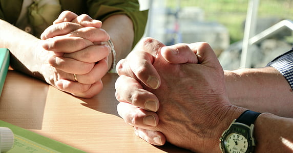 two man and woman's hand on top of table thumbnail