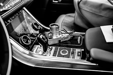 grayscale photography of point-and-shoot camera on vehicle center stack thumbnail