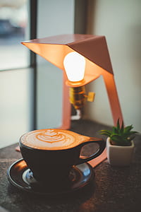 coffee on teacup beside desk lamp thumbnail
