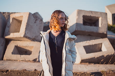 woman wearing bubble coat standing near concrete blocks thumbnail