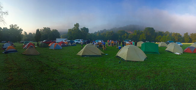 Tents on Green Grass Field Near Mountain thumbnail