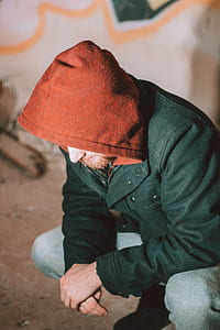 man kneeling down wearing jacket thumbnail
