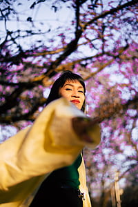woman walking under tall tree thumbnail