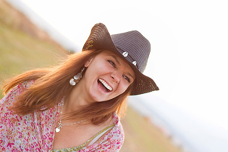 selective focus photo of happy woman wearing red and white floral top and black hat thumbnail