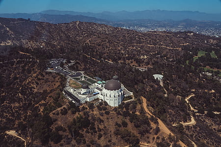 aerial view photography of white concrete building surrounded by trees and houses thumbnail