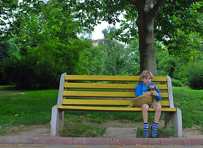 boy sitting on bench while hugging pet thumbnail