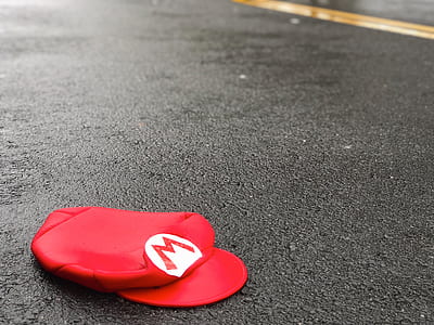 red Mario cap on black pavement thumbnail
