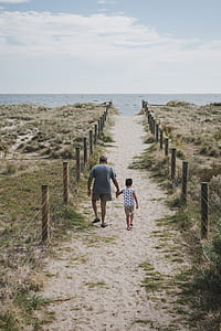 man and boy walking through beach thumbnail